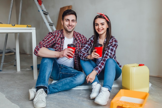 Young couple doing repairs, have a break time with cup of tasty coffe