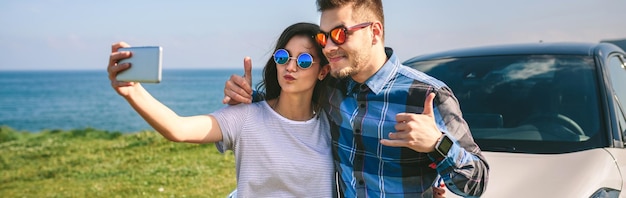 Young couple doing a selfie on the car