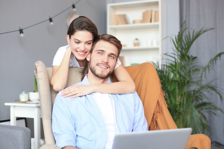 Photo young couple doing some online shopping at home, using a laptop on the sofa.