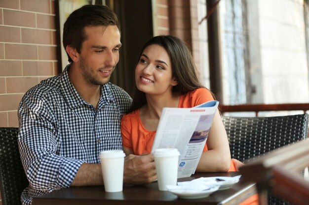 Young couple drink coffee in cafe outdoors