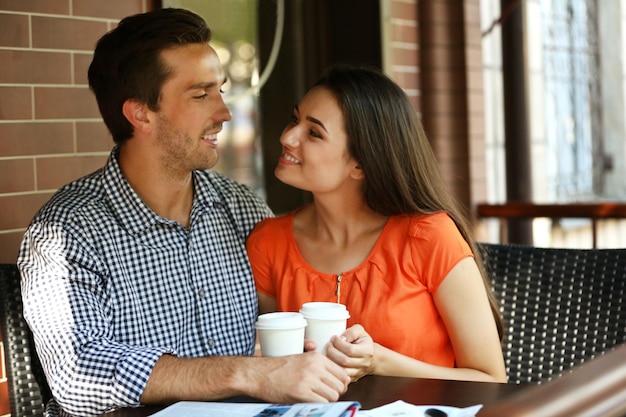 Young couple drink coffee in cafe outdoors