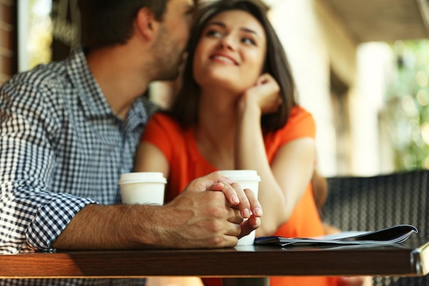 Young couple drink coffee in cafe outdoors