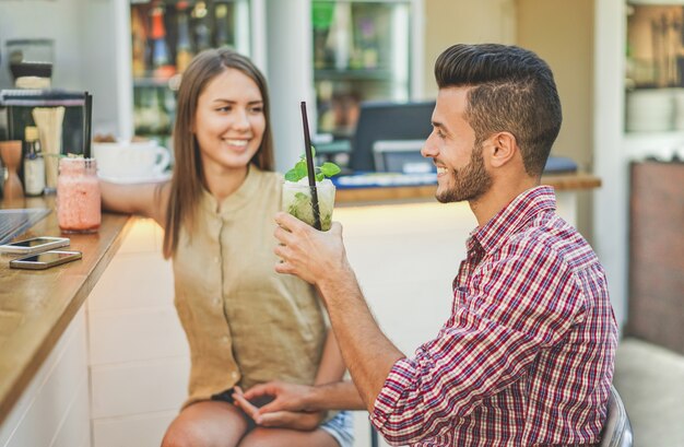 写真 ファッションバーのレストランで食前酒のカクテルを飲む若いカップル