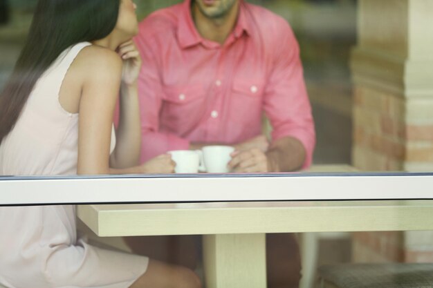 Young couple drinking tea and talking in cafe