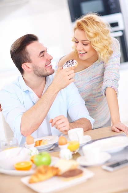 young couple eating breakfast in the kitchen