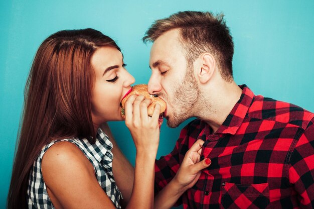 Foto giovane coppia che mangia un hamburger