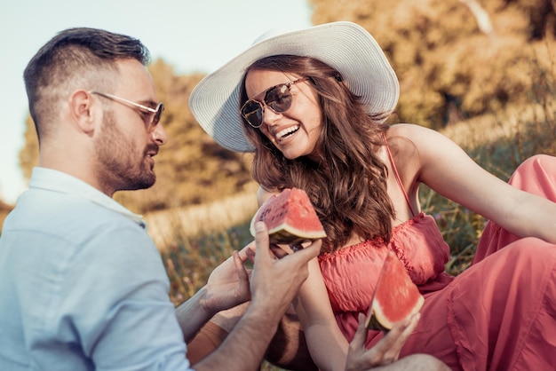 Young couple eating watermelon on a picnic date