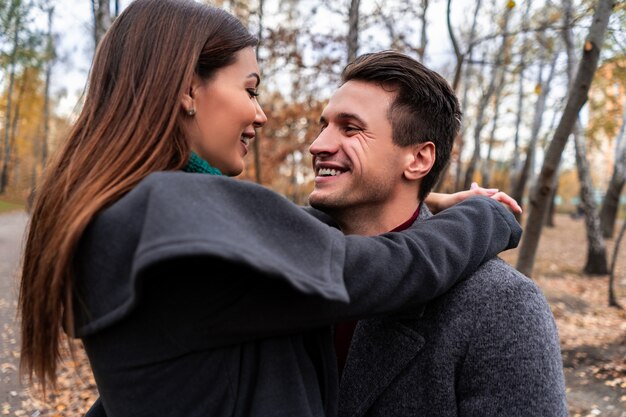 The young couple embracing in the autumn park