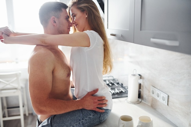 Young couple embracing and kissing each other on the kitchen.