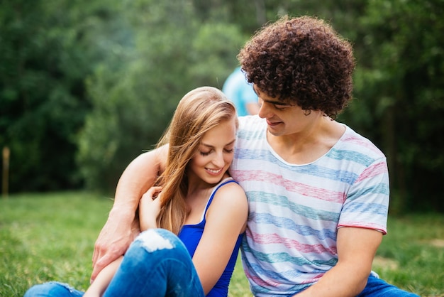 Photo young couple embracing on a picnic in the nature they are both happy and satisfied