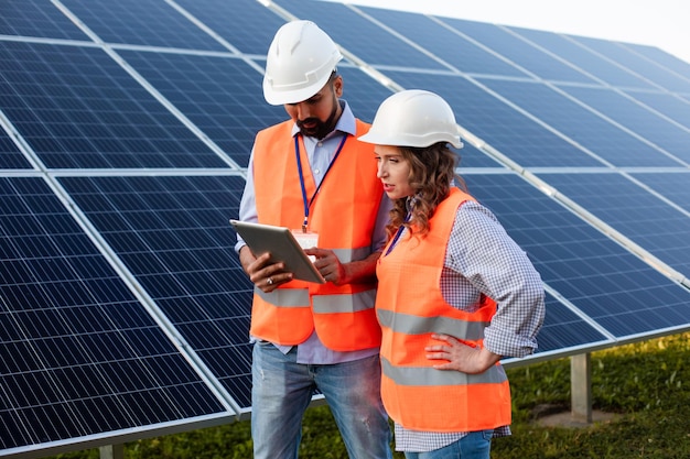 Young couple of engineers are working at a solar station