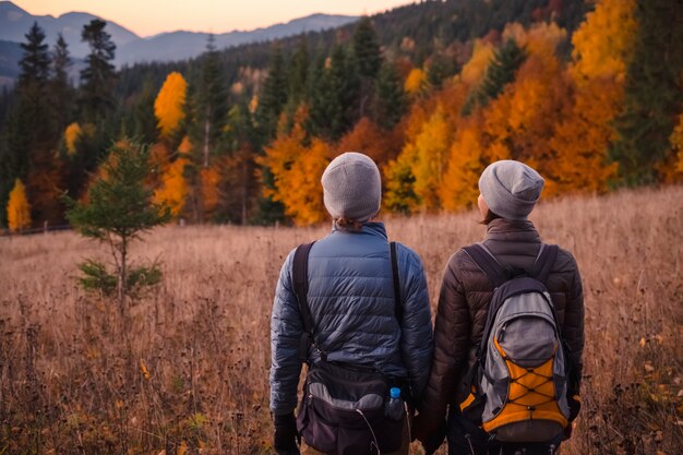 Photo young couple enjoying beautiful autumn forest in the mountains