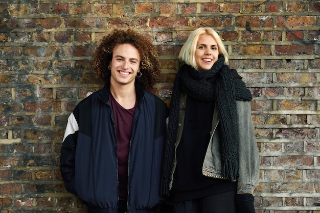 Young couple enjoying Camden town in front of a brick wall typical of London