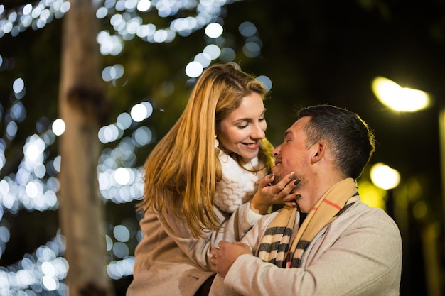 Young couple enjoying christmas and new year in the street