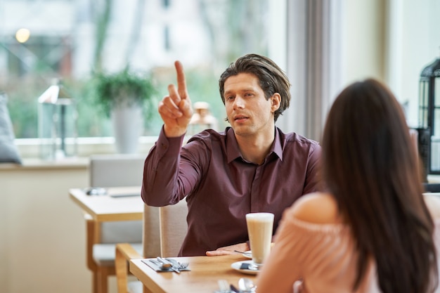 young Couple Enjoying Coffee And Cake In Cafe