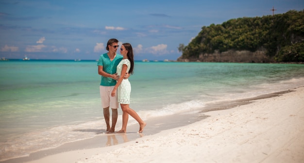 Young couple enjoying each other on sandy white beach