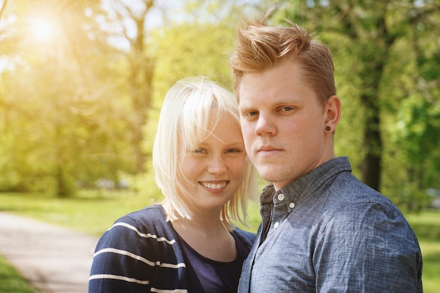 young couple enjoying sunny spring day in a park real people with sun flare light leak filter