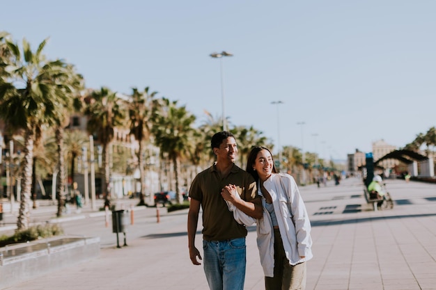 Young couple enjoying a sunny stroll along Barcelona palmlined promenade