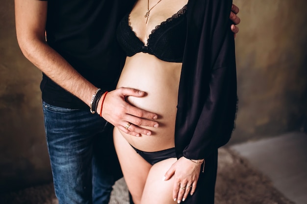 Young couple expecting a baby. pregnant girl strokes belly. waiting for a miracle.