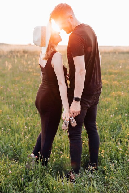 Young couple expecting a baby in rays of the summer setting
sun. carefree and happy. waiting for child. walking with whole
family. pregnancy and care. happy moments. fertility of man and
nature.