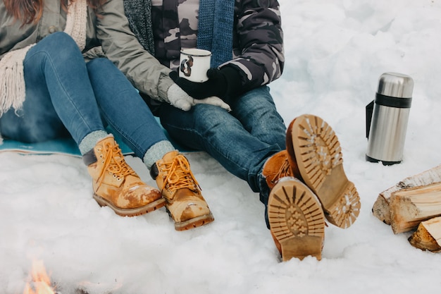 young couple feet at the forest nature park in cold season. 