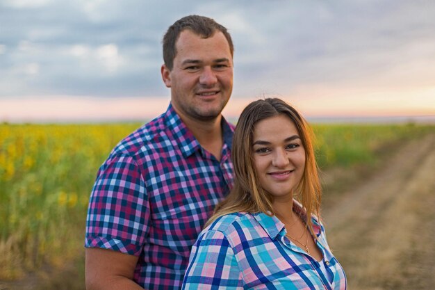 Young couple in a field of sunflowers pregnant girl in sunflowers