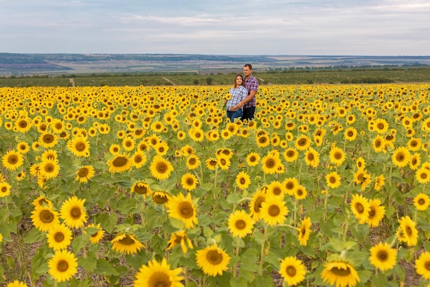 Giovane coppia in un campo di girasoli ragazza incinta in girasoli