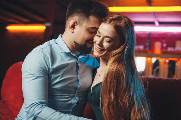 Foto giovani coppie che flirtano al loro primo appuntamento al primo bacio di san valentino del ristorante