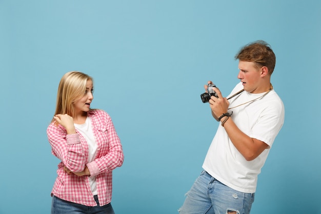 Young couple friends guy and woman in white pink empty blank t-shirts posing 