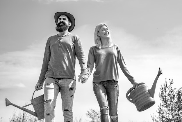 Young couple gardening in the garden cheerful couple of farmers standing in vegetable garden a farme