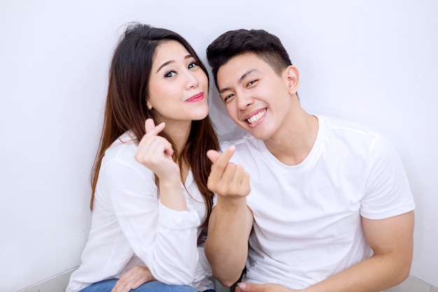 Young couple gesturing money on studio