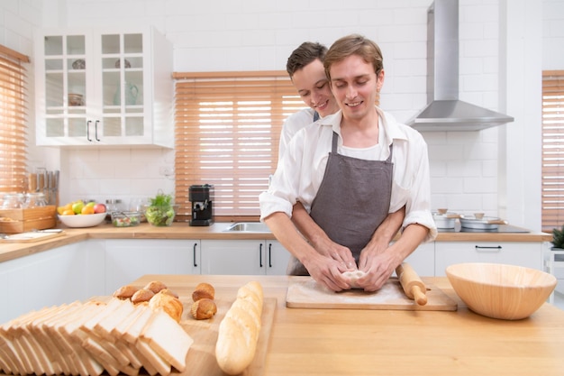 Young couple go to the kitchen and learn how to bake cookies online Do it and play happily