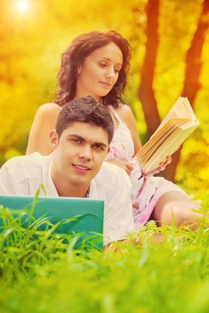 A young couple on grass in park in evening