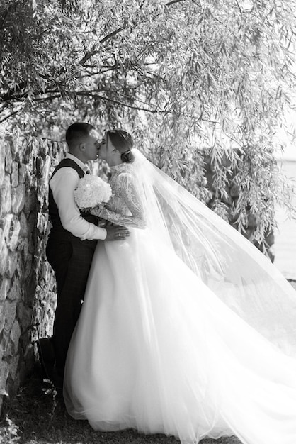 Foto giovane coppia lo sposo in un abito scozzese e la sposa in un elegante abito bianco