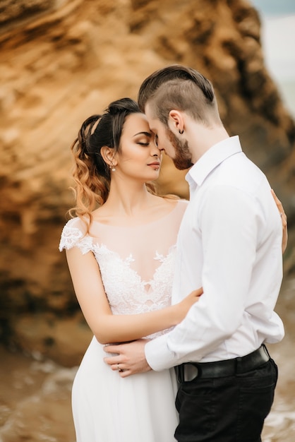 Photo young couple groom with the bride on a sandy beach at a wedding walk