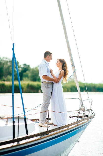 Young couple guy and girl on a white sailing yacht
