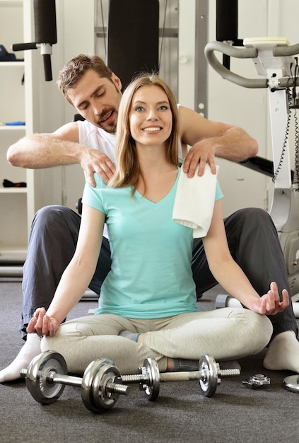 Giovane coppia in palestra, uomo che fa massaggi