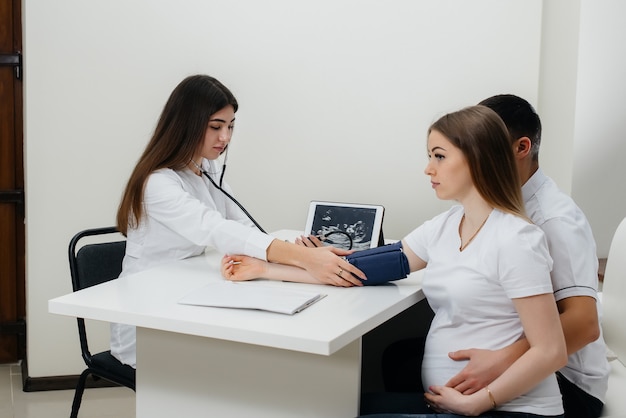 초음파 검사 후 산부인과 의사의 상담에서 젊은 부부. 임신과 건강 관리