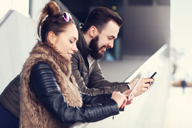 young couple hanging out in city and texting