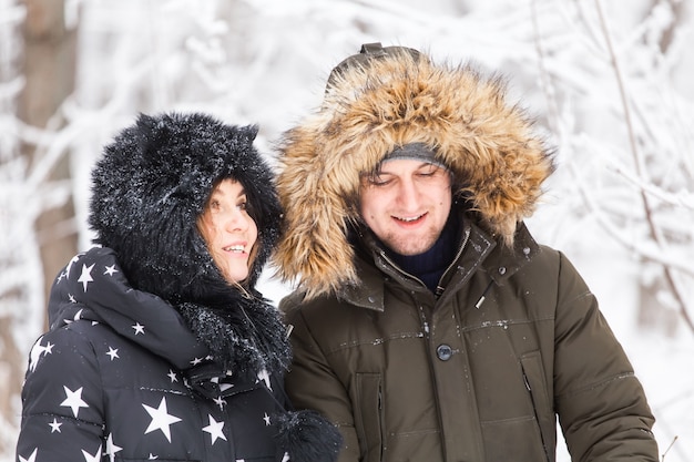 Young couple have fun in a snowy park. Winter season.