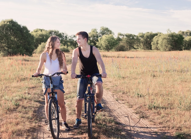 Le giovani coppie che hanno una bici guidano in natura