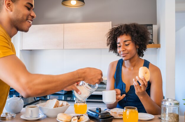 Young couple having breakfast at home.