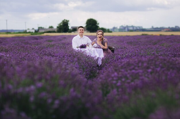 Young couple having fun in a lavender field on a summer day