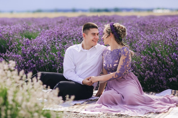 Young couple having fun in a lavender field on a summer day
