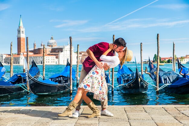  young couple having fun while visiting Venice - Tourists travelling in Italy and sightseeing the most relevant landmarks of Venezia - Concepts about lifestyle, travel, tourism