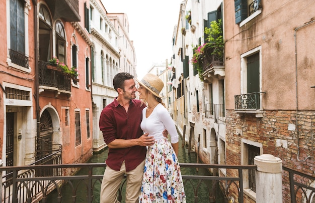  young couple having fun while visiting Venice - Tourists travelling in Italy and sightseeing the most relevant landmarks of Venezia - Concepts about lifestyle, travel, tourism