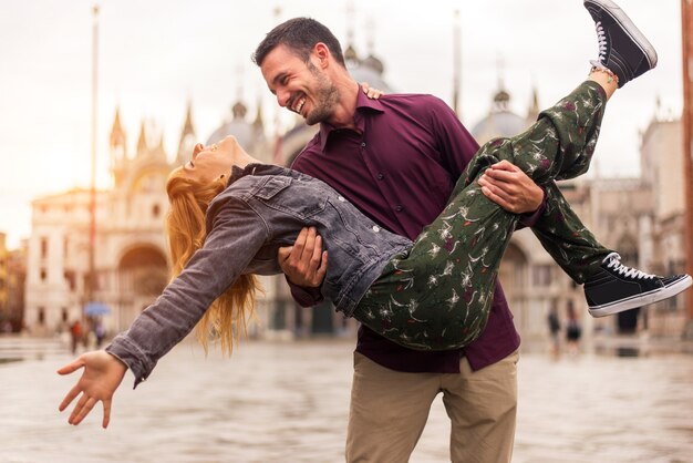 ヴェネツィアを訪問しながら楽しんでいる若いカップル-イタリアを旅行し、ヴェネツィアの最も関連するランドマークを観光する観光客-ライフスタイル、旅行、観光についての概念