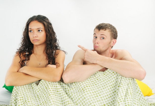 Young couple having happy leisure time in bed