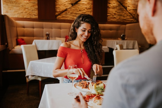 Young couple having lunch with white wine in the restaurant