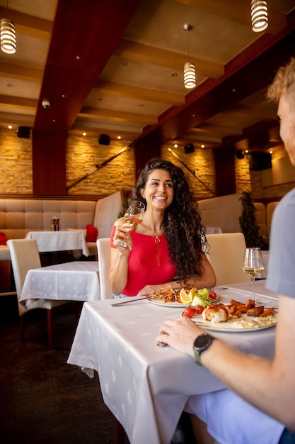 Young couple having lunch with white wine in the restaurant